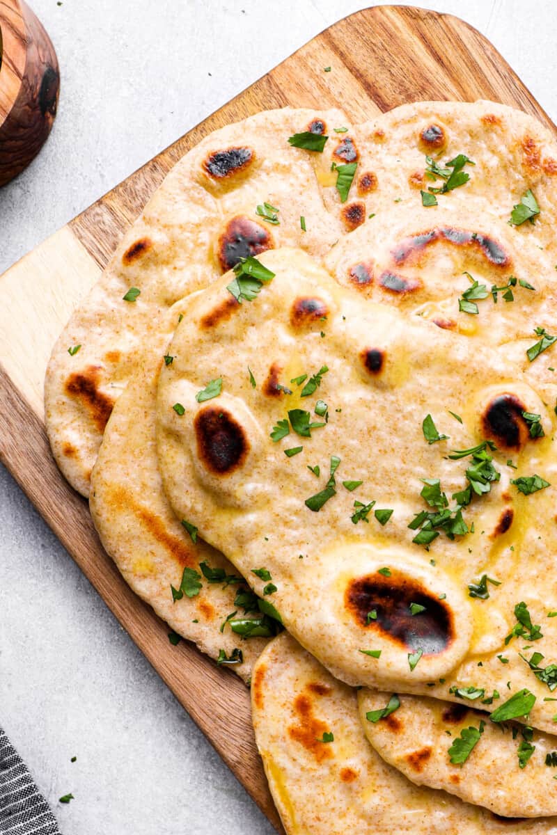 naan stacked up on a cutting board
