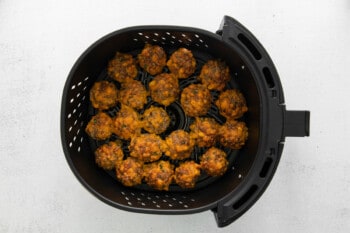 cooked air fryer sausage balls in the basket of an air fryer.
