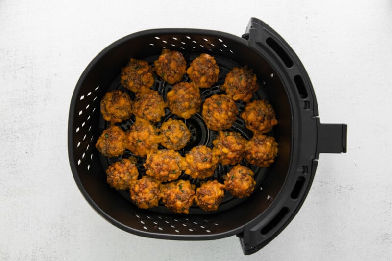 cooked air fryer sausage balls in the basket of an air fryer.