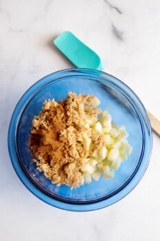 combining apples and cinnamon in a mixing bowl
