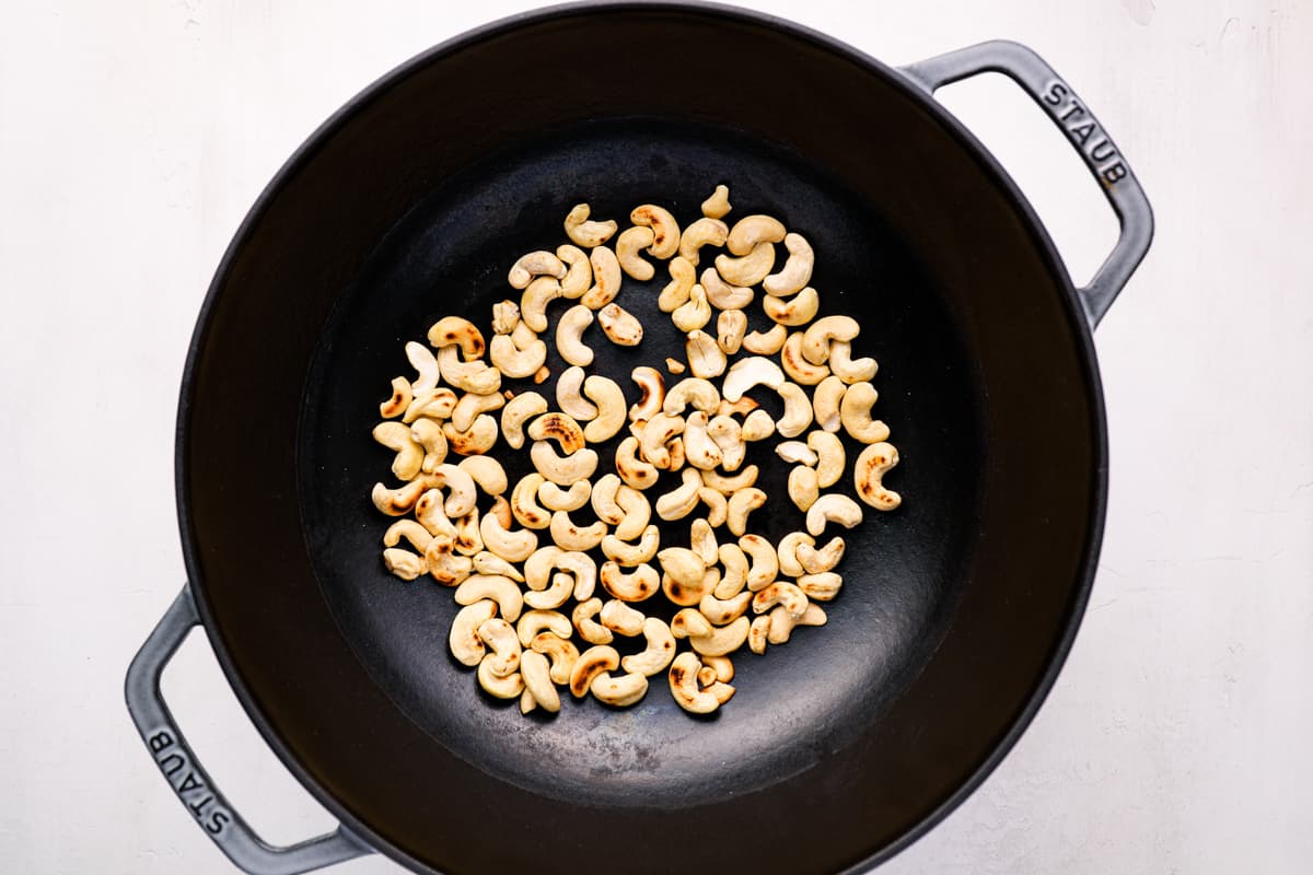 toasted cashews in a cast iron wok.