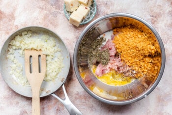 bowl filled with turkey meatloaf ingredients, next to a skillet filled with diced onions