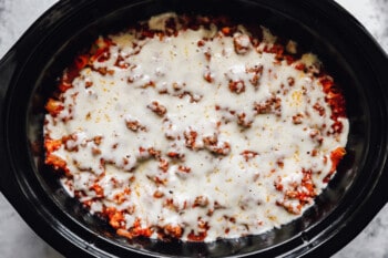 parmesan cheese topped crockpot baked ziti in a crockpot.