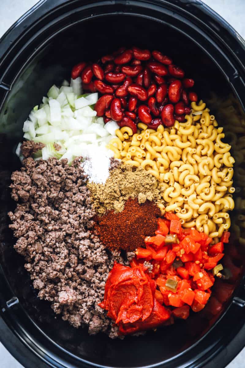overhead view of ingredients for crockpot chili mac in a crockpot.