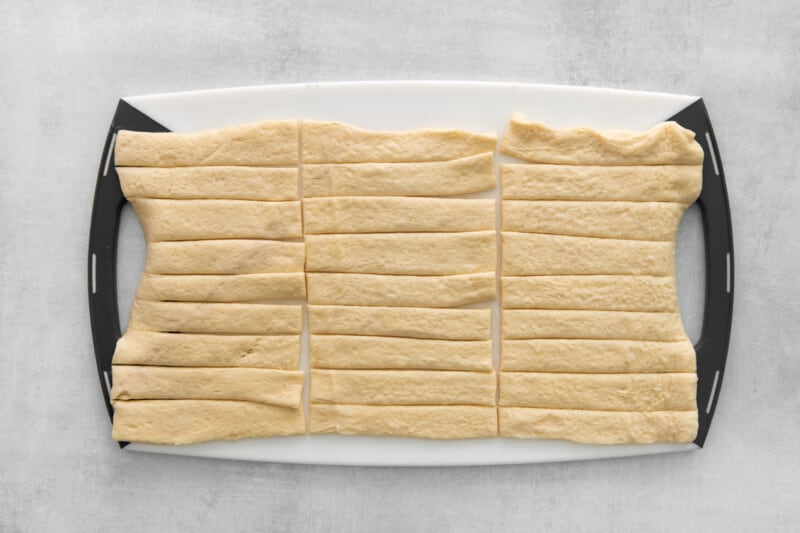 strips of dough lined up on a cutting board