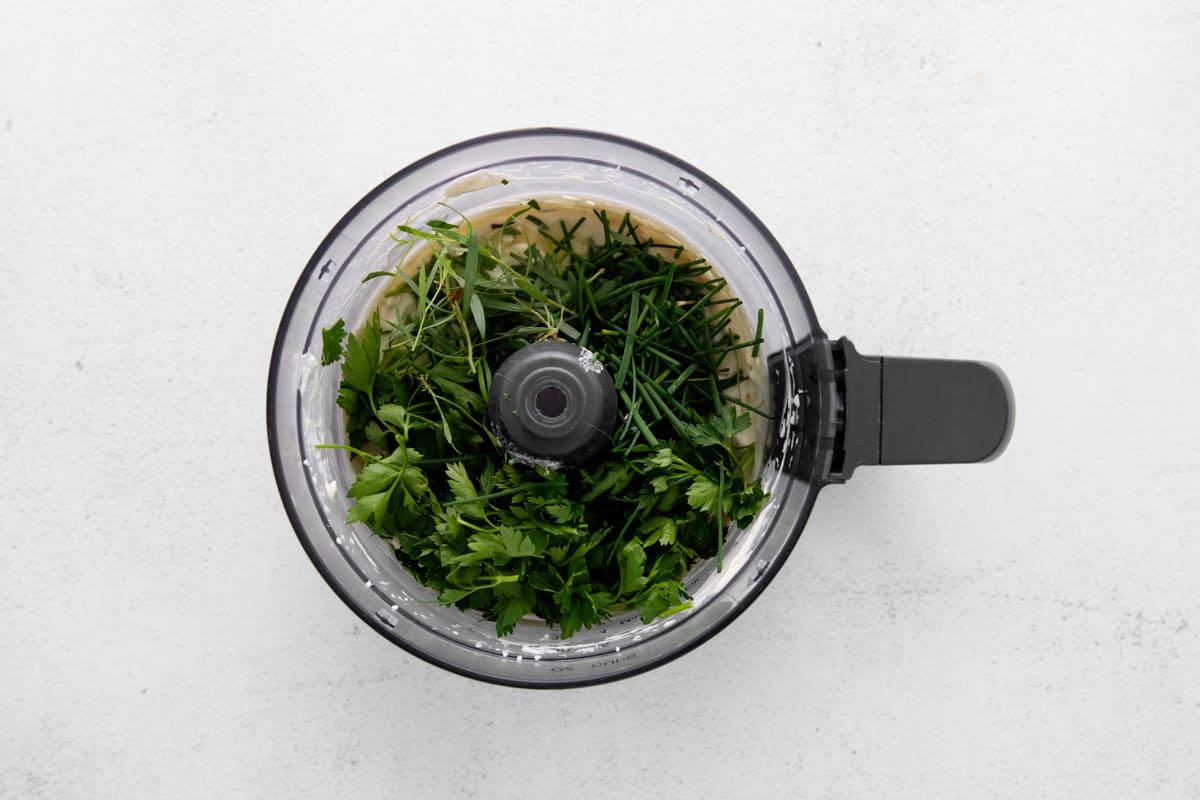 Add the herbs to the food processor. - 8