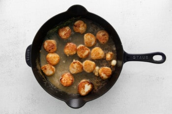 scallops cooking in butter, in a cast iron skillet