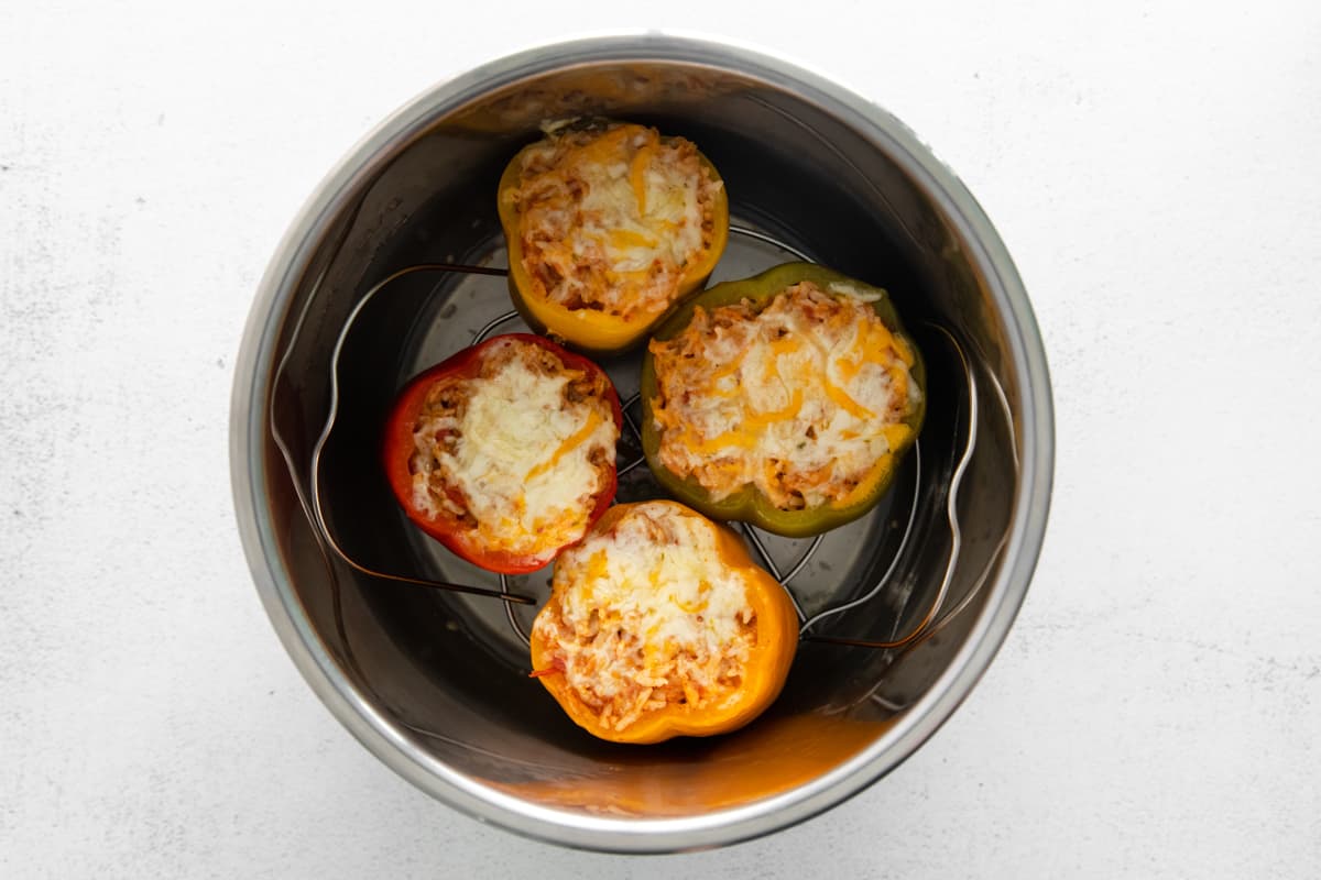 Cheese sprinkled over instant pot stuffed peppers in an instant pot.