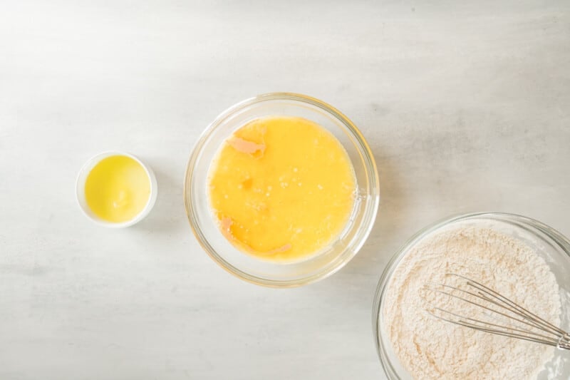 overhead view of wet ingredients for belgian waffles in a glass bowl.