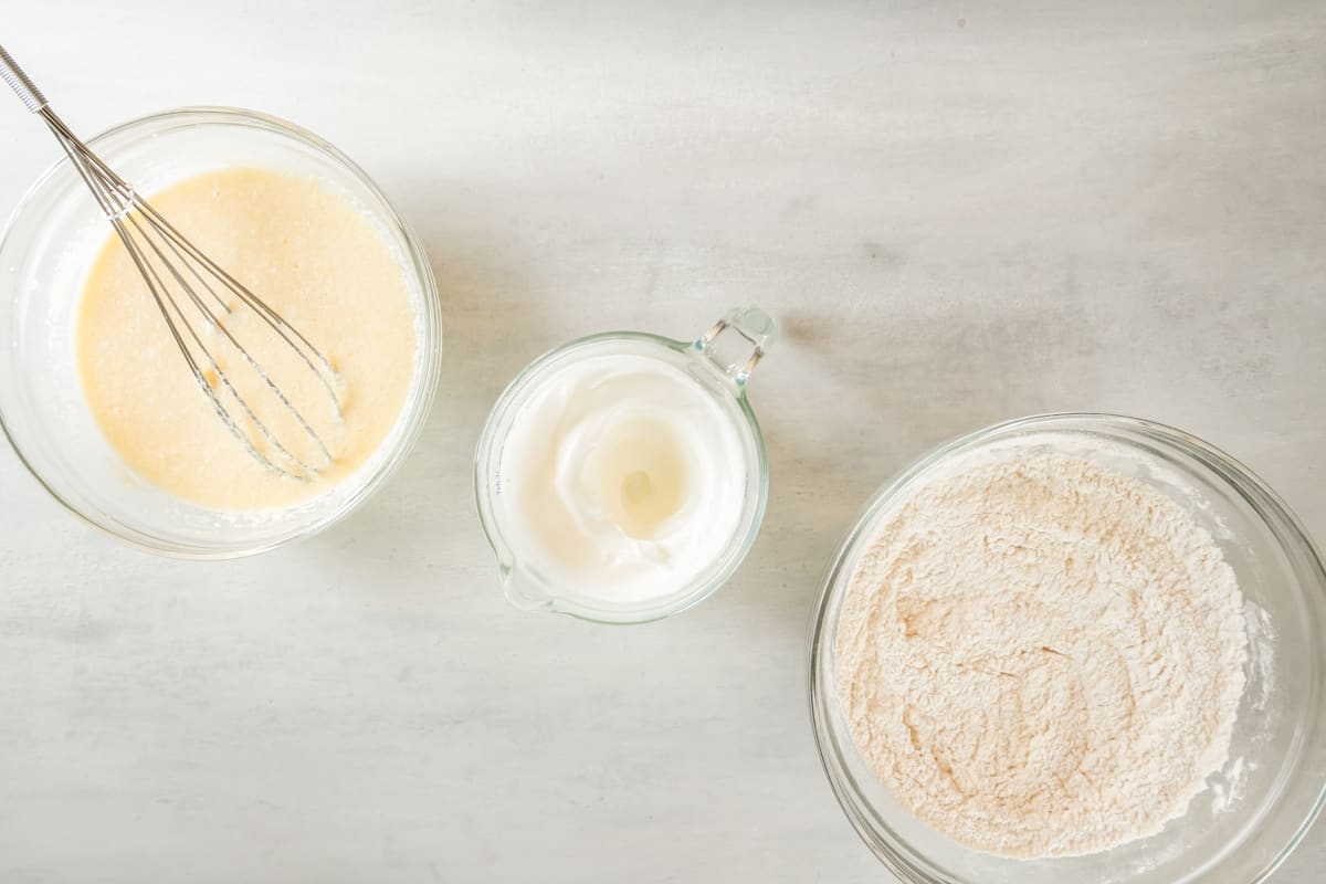 overhead view of whipped egg whites for belgian waffles in a glass bowl.