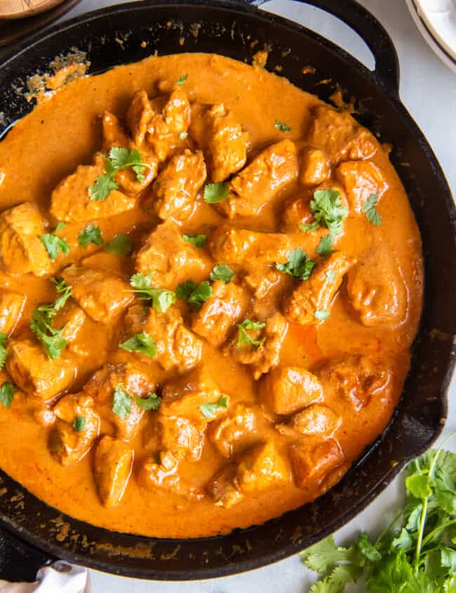 close up of indian butter chicken in a cast iron skillet.