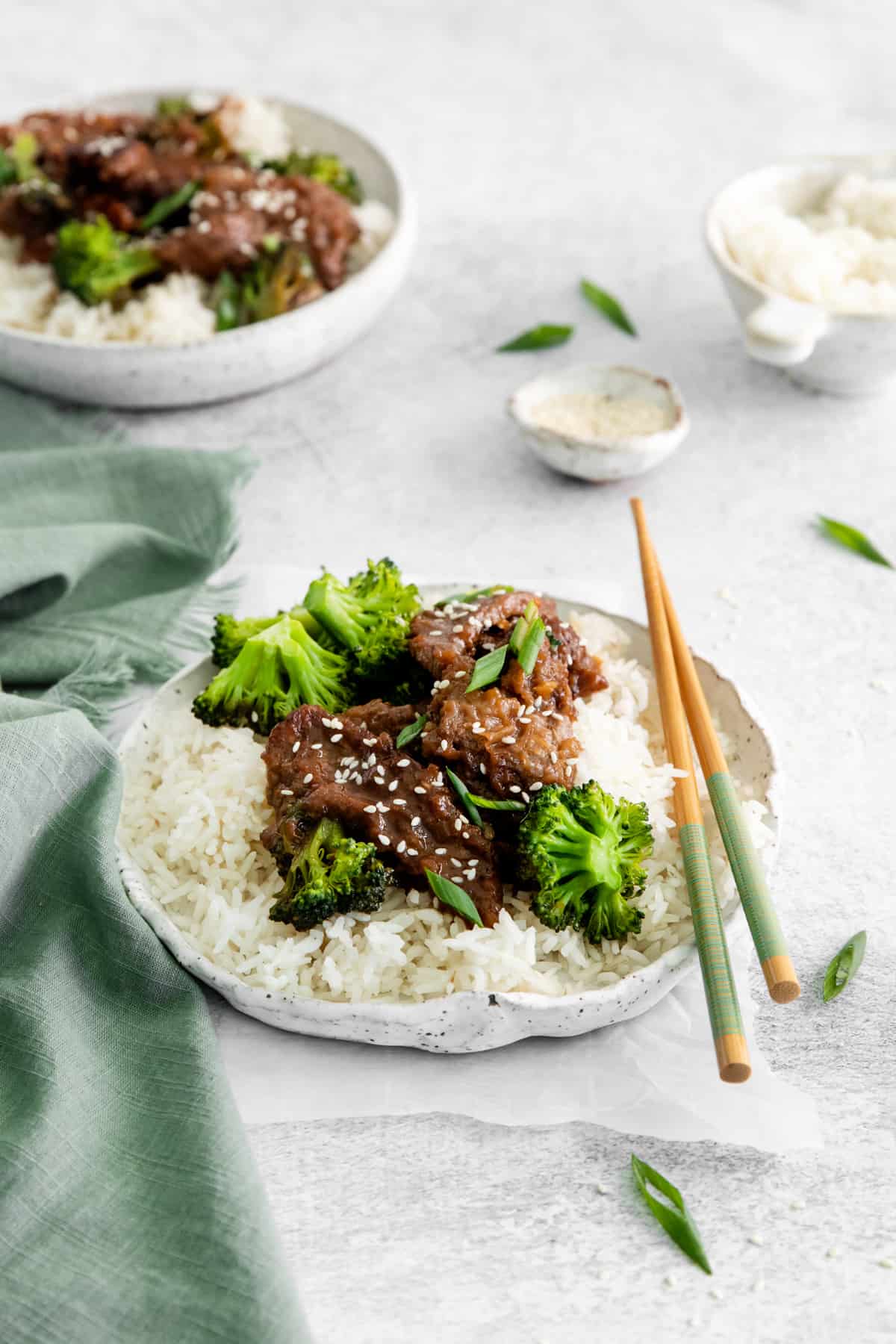 instant pot mongolian beef over rice on a white plate with chopsticks.