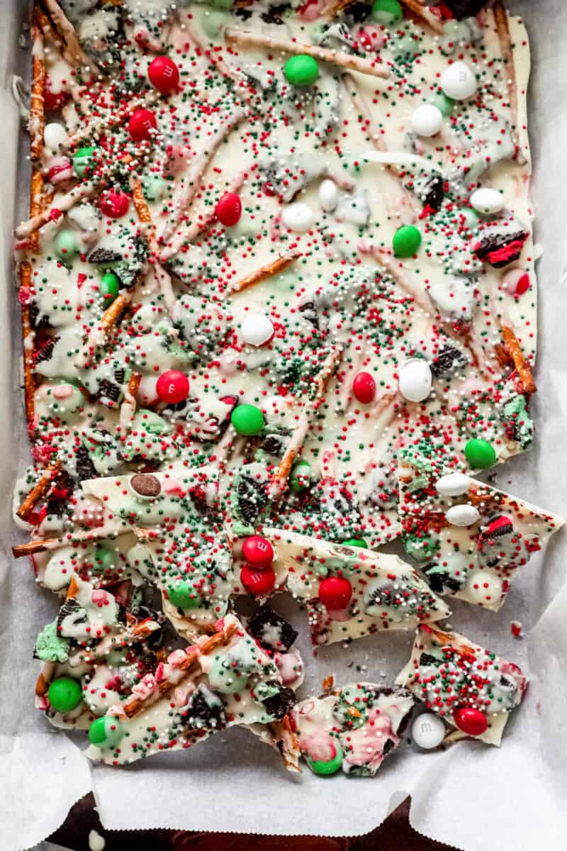 breaking up pieces of chocolate candy bark in a sheet pan