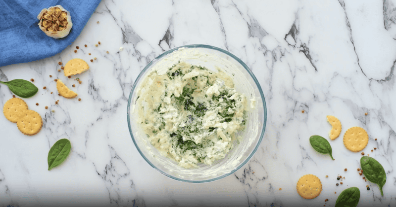 spinach dip ingredients in a glass bowl.