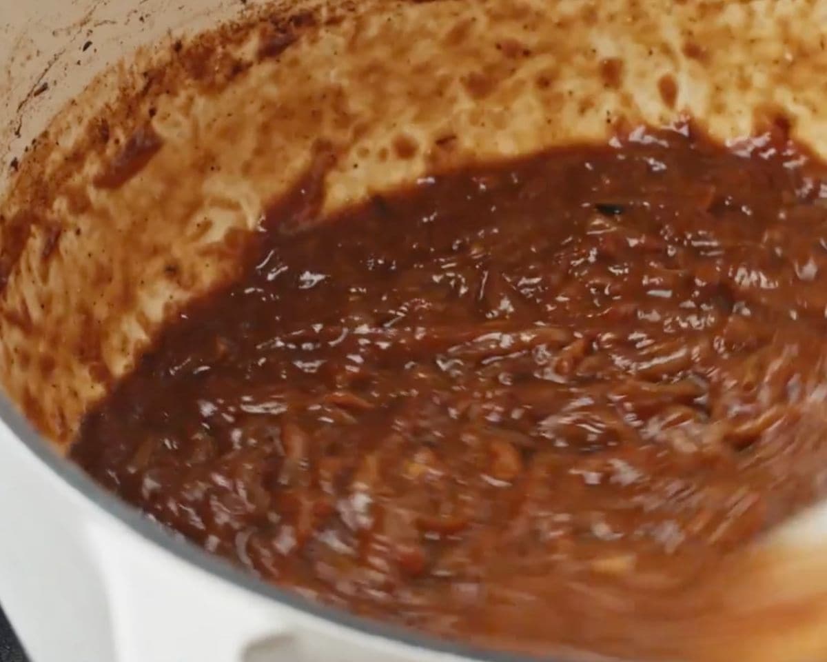 Deeply caramelized onions with dark brown fond developing on the bottom of the pot