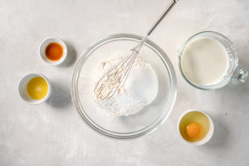 dry ingredients for buttermilk pancakes in a glass bowl with a whisk.