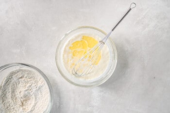 wet ingredients for buttermilk pancakes in a glass bowl with a whisk.