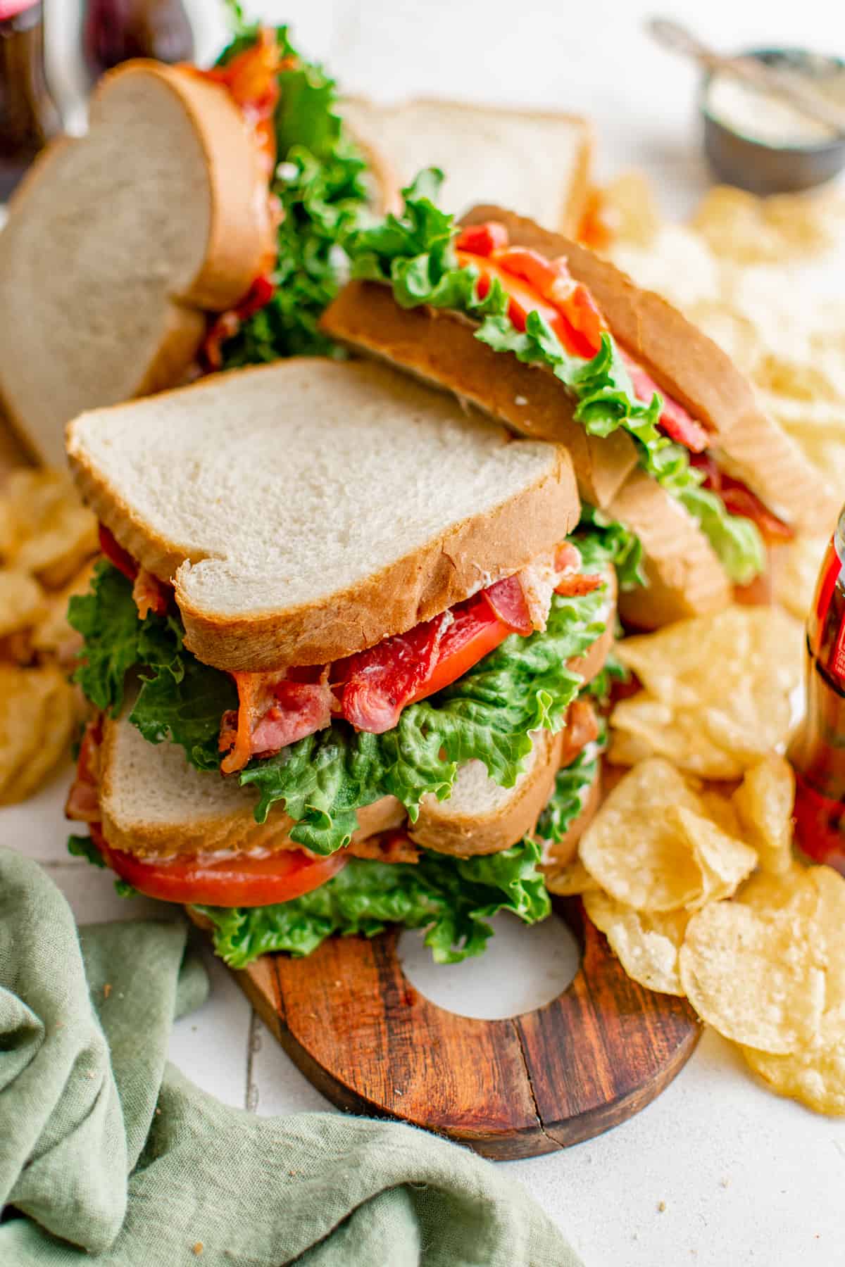 close up of blt sandwiches resting on a bed of potato chips.