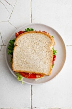 a fully assembled blt sandwich on a white plate.
