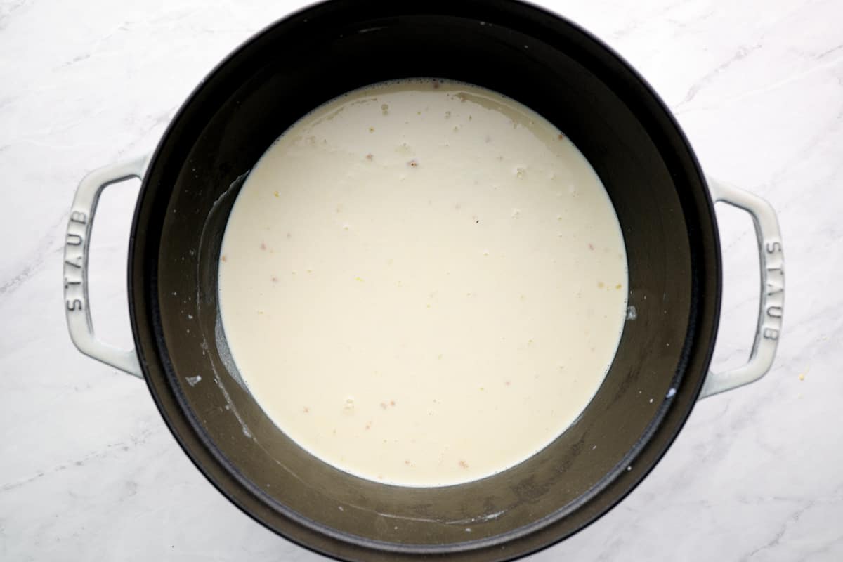 Adding milk and cream to the roux. 