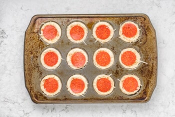 overhead view of unbaked pizza cupcakes in an cupcake tin.