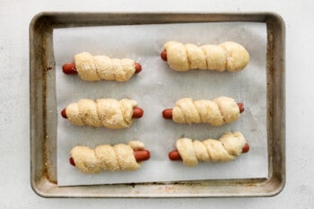 unbaked pretzel dogs lined up on a tray