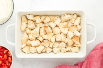 chunks of bread layered along the bottom of a casserole dish