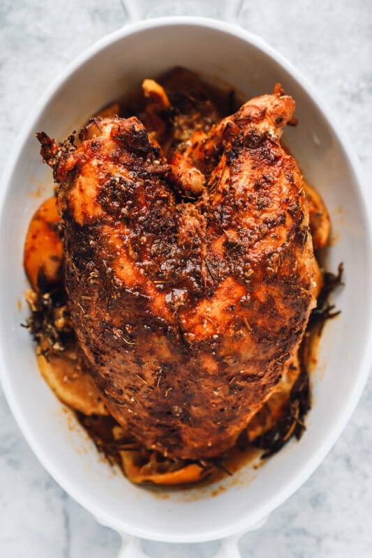 baked thanksgiving turkey breast in a white roasting pan.