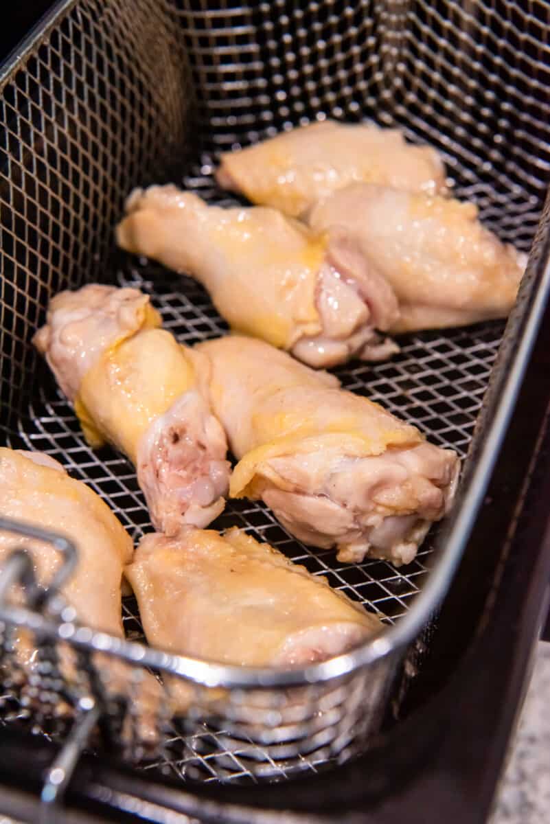 chicken wings in a deep fryer basket.