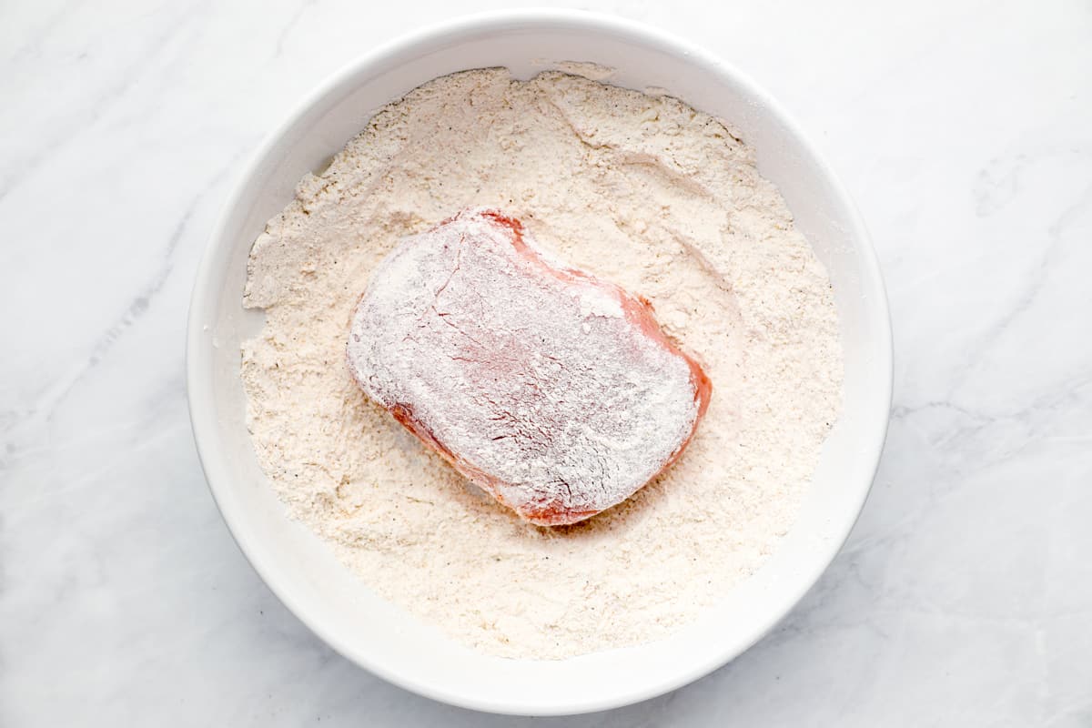 dredging a pork chop in flour