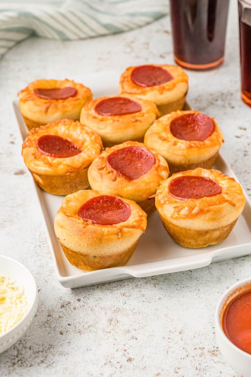 8 pizza cupcakes on a white serving tray.