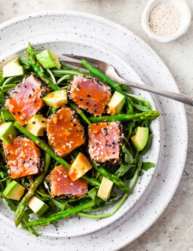 Ahi Tuna with asparagus and avocado, on speckled white dish