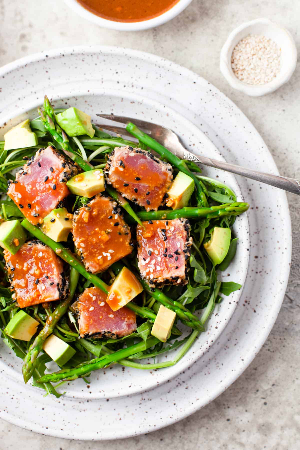 seared Ahi Tuna with asparagus and avocado, on speckled white dish
