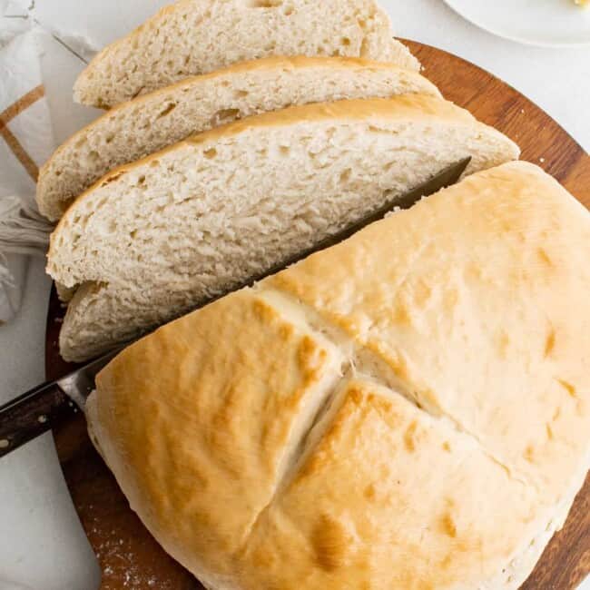 cutting a loaf of skillet bread into slices
