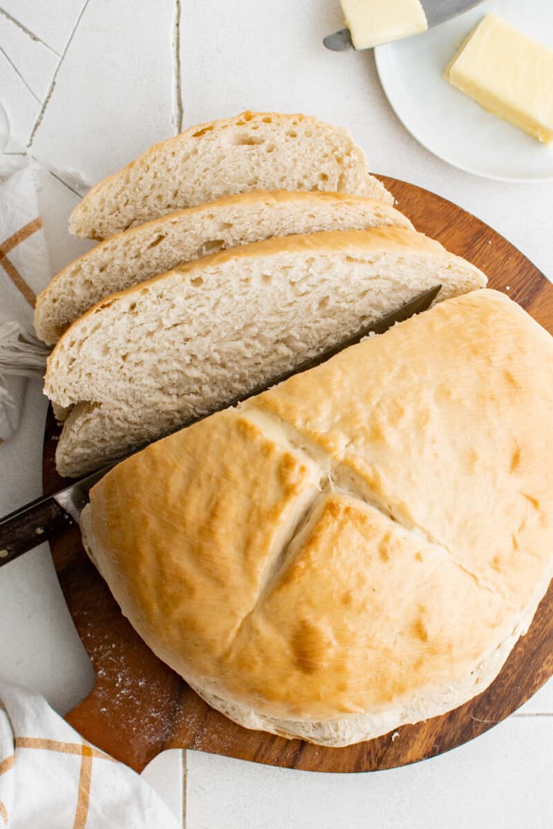 cutting a loaf of skillet bread into slices