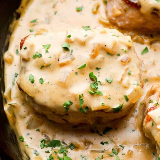 close up on smothered pork chops in a skillet