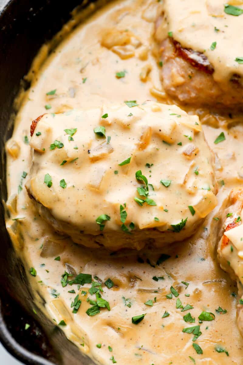 close up on smothered pork chops in a skillet