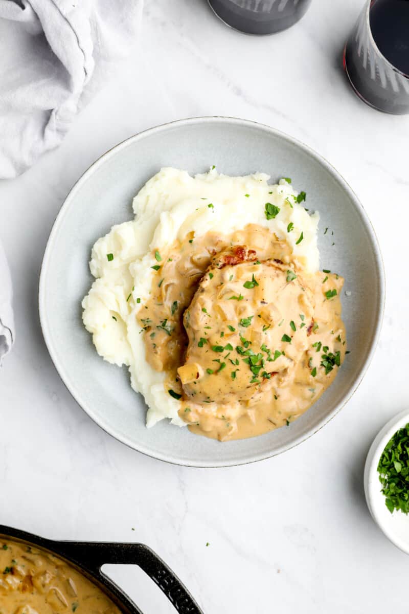 plate of smothered pork chops at the center of a table scape