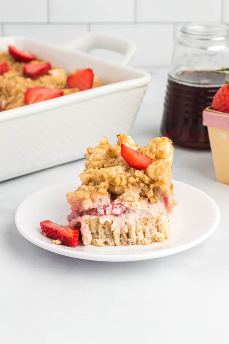 a piece of French toast casserole on a plate, next to a casserole dish