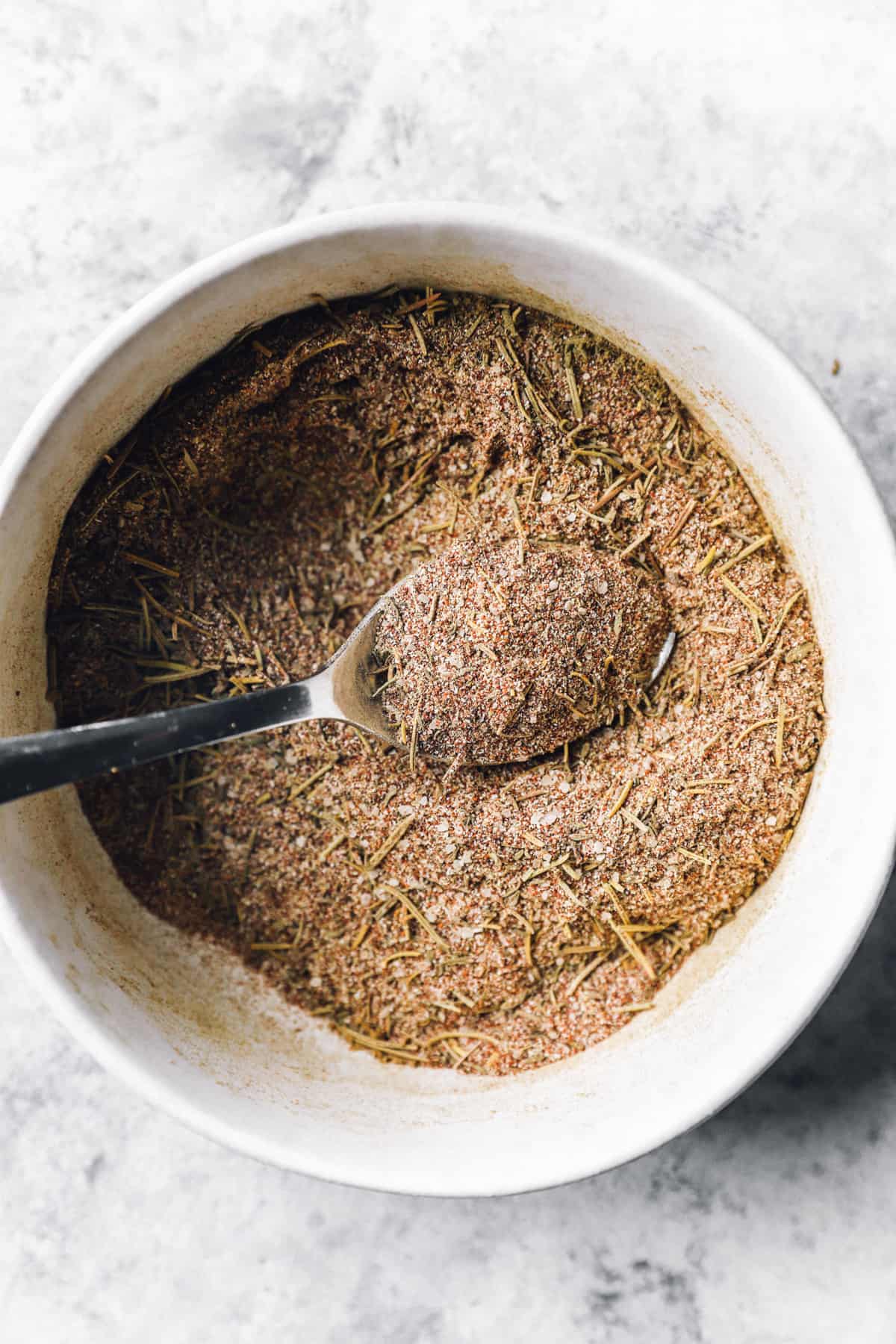 turkey rub in a white bowl with a spoon.