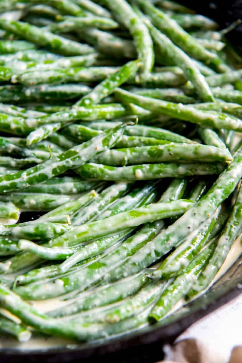 close up of creamed green beans in a cast iron skillet.