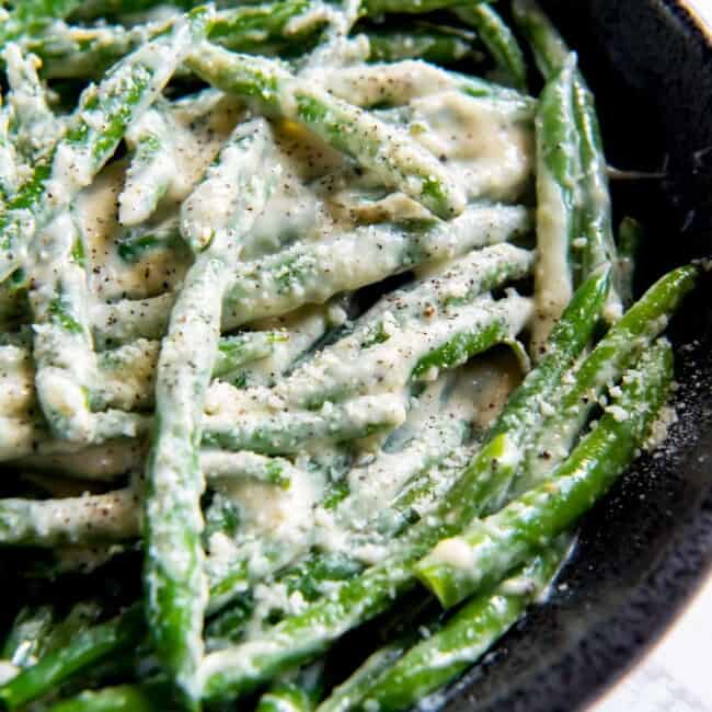 creamed green beans in a cast iron skillet.