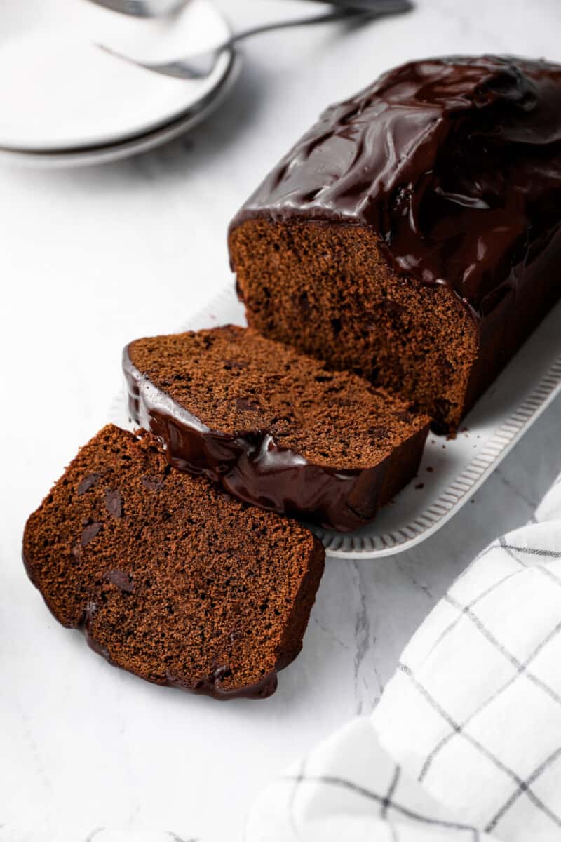 sliced chocolate pound cake on a white serving plate.