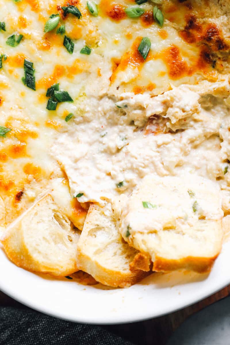 close up on pieces of bread in hot crab dip