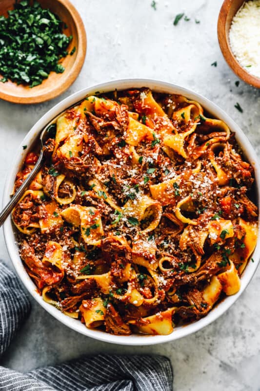 overhead view of slow cooker beef ragu in a white bowl with a fork.