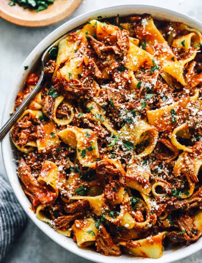 overhead view of slow cooker beef ragu in a white bowl with a fork.