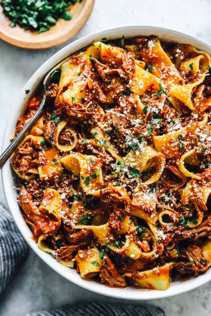 overhead view of slow cooker beef ragu in a white bowl with a fork.