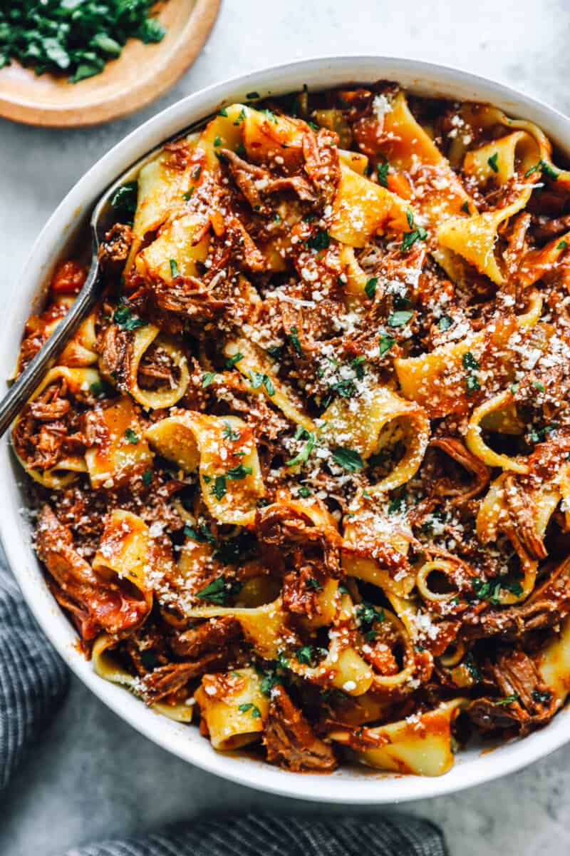 overhead view of slow cooker beef ragu in a white bowl with a fork.