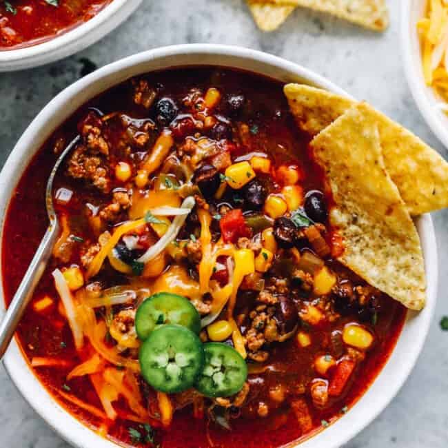 overhead view of crockpot taco soup in a white bowl with a spoon.