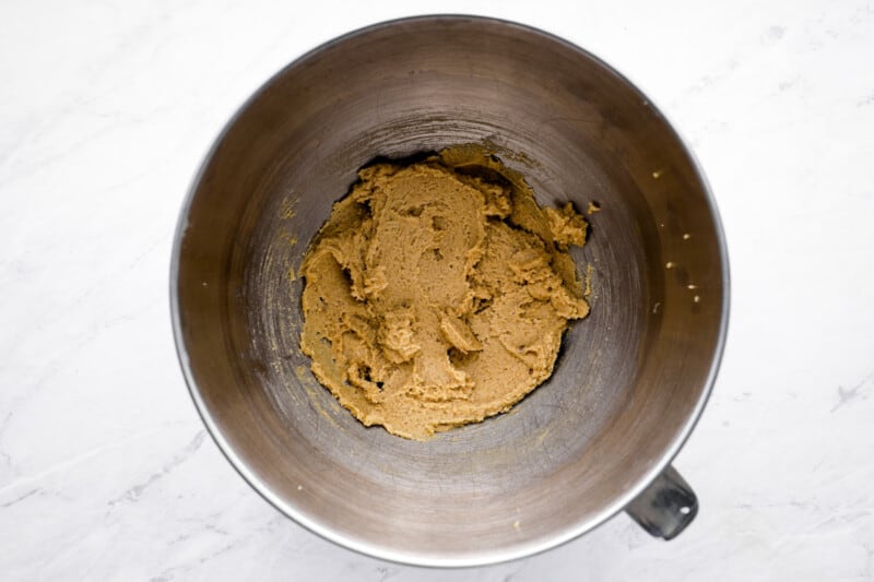 overhead view of creamed butter and brown sugar in a stainless mixing bowl.